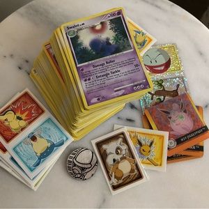 Bundle of 100+ Pokémon cards with stickers and collectible items